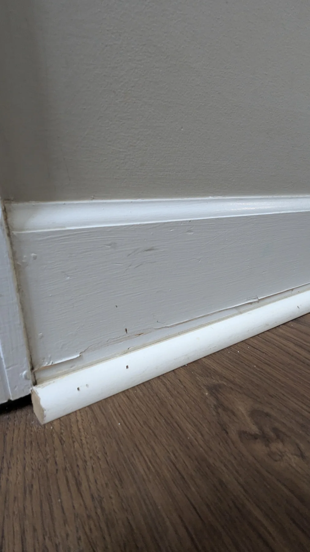 White baseboard against a gray painted wall