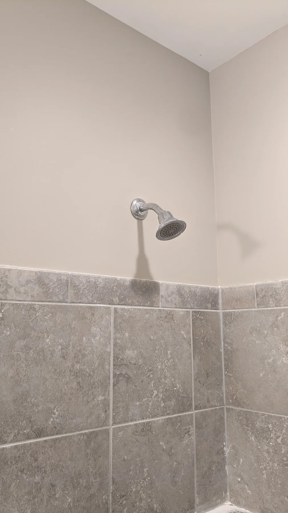 Patched bathroom wall above a tile edge