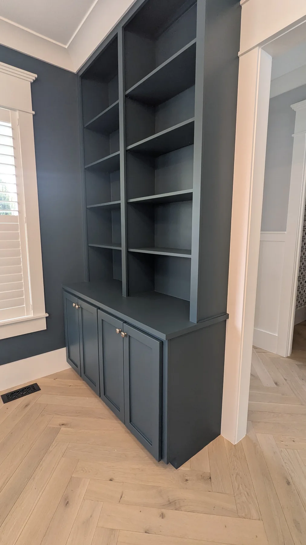 Deep blue painted built-in shelves and lower cabinets