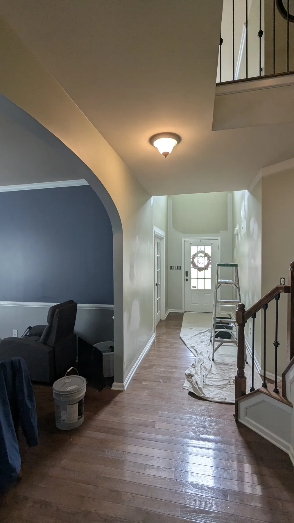 Painted entry hall with an arched doorway and staircase