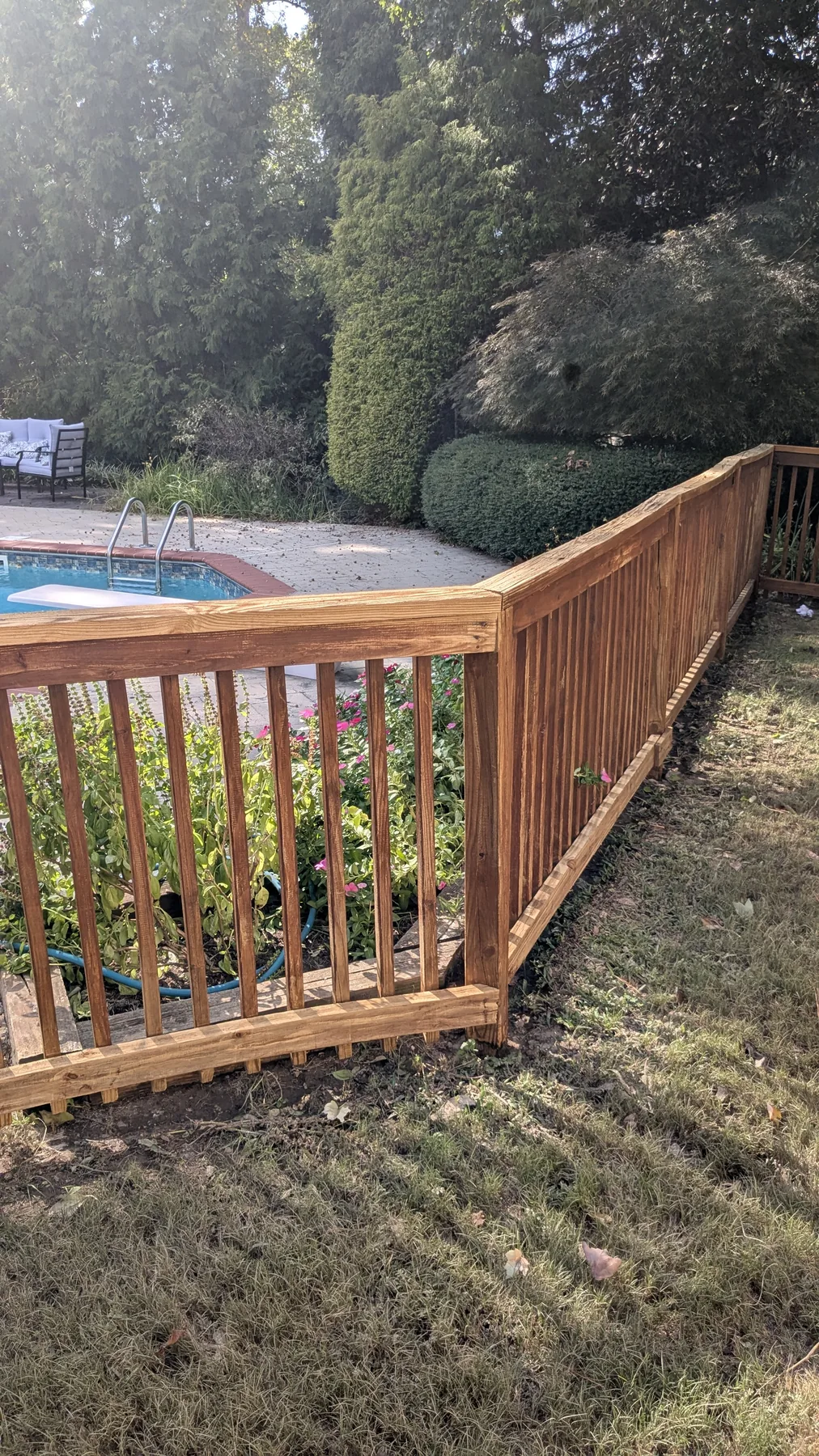 Warm wood fence and gate surrounding an outdoor pool area