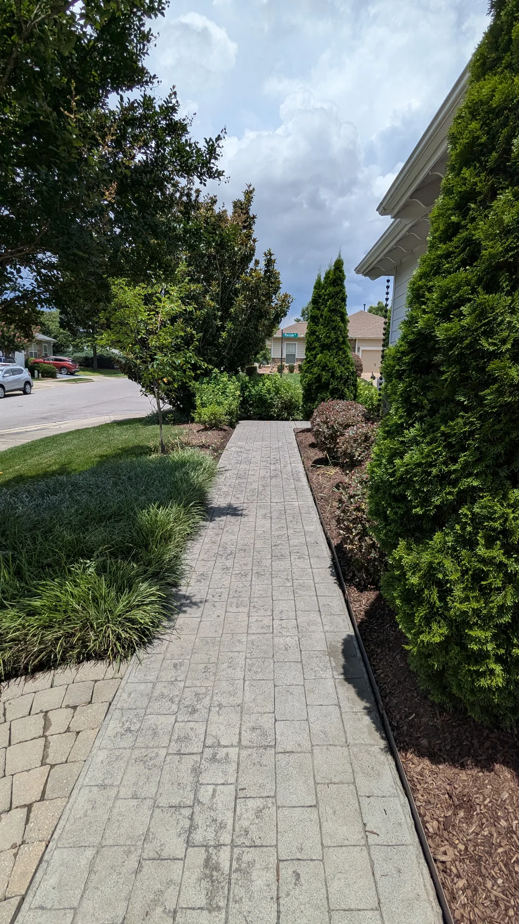 Clean paver walkway leading through a garden