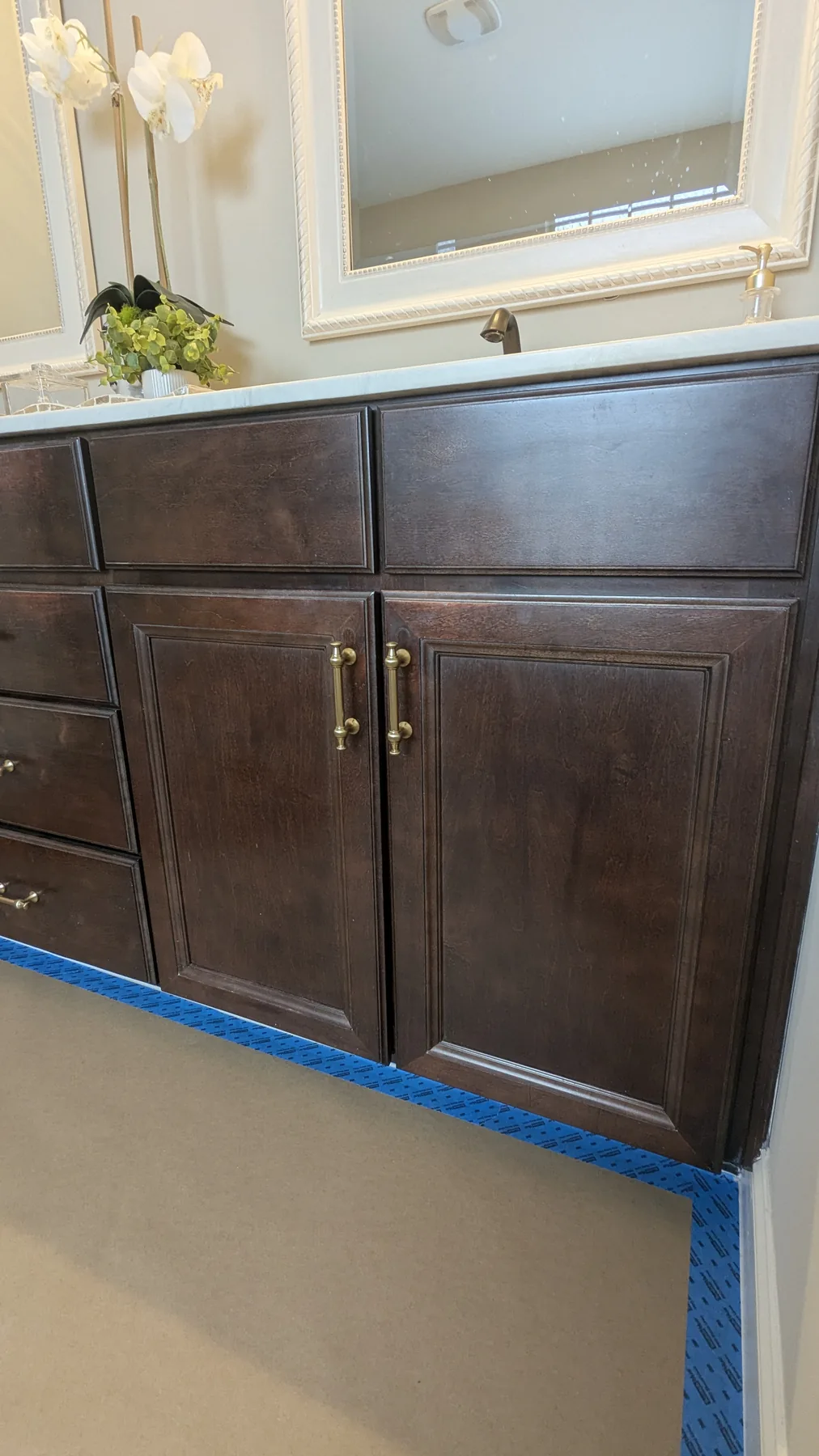Dark wood vanity with protected floor during preparation
