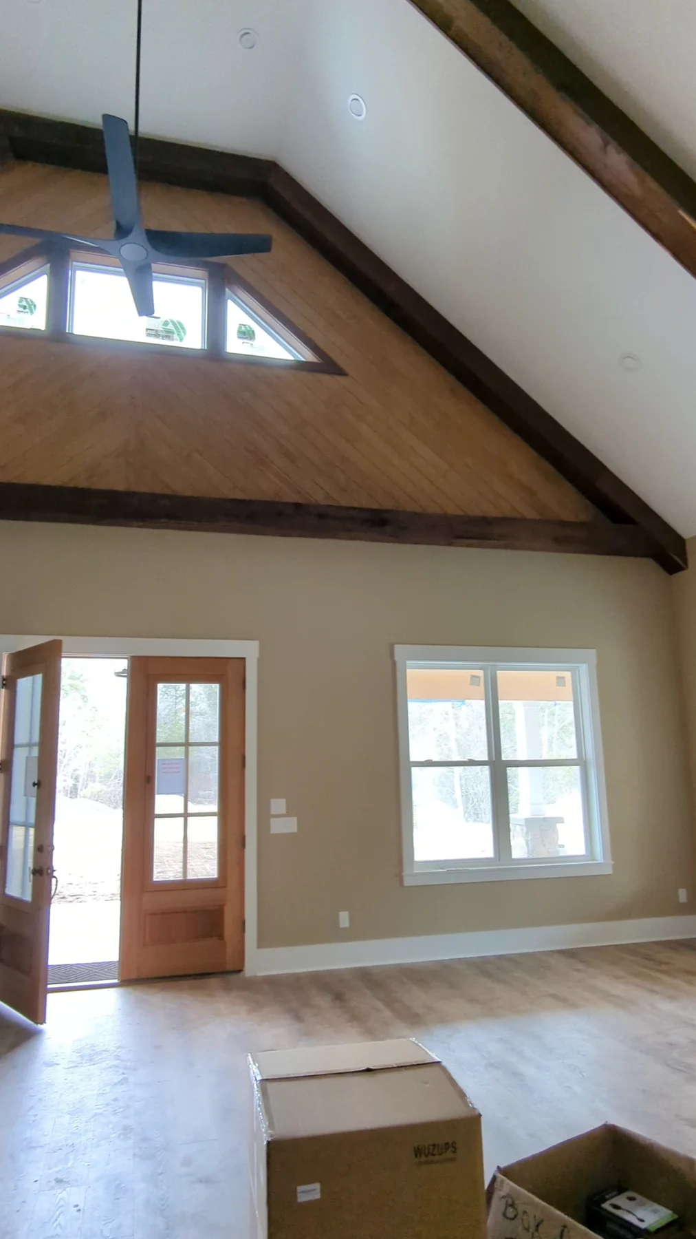 Painted room with exposed timber ceiling beams and white window trim