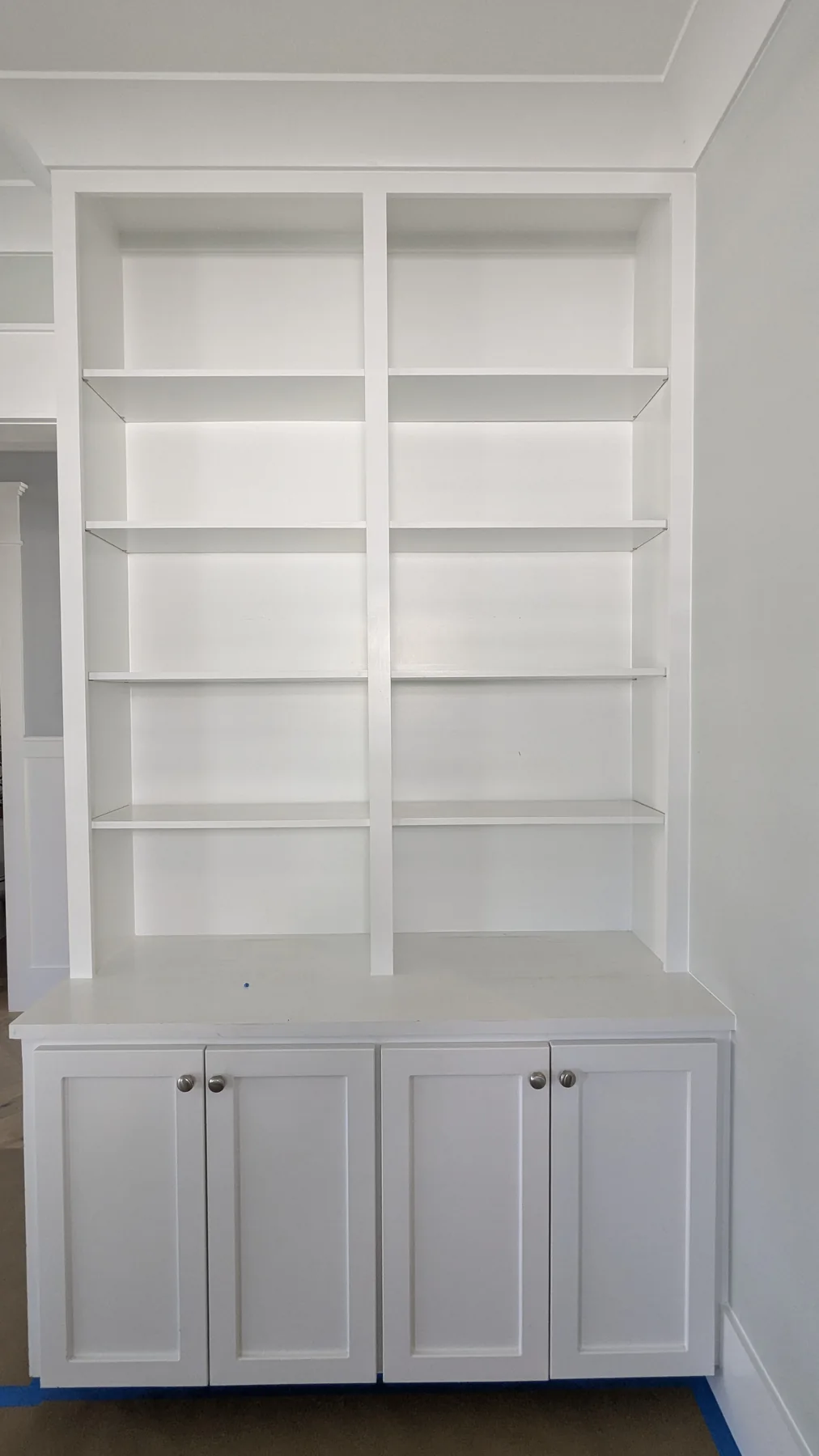 White built-in shelving and paneled lower cabinet doors