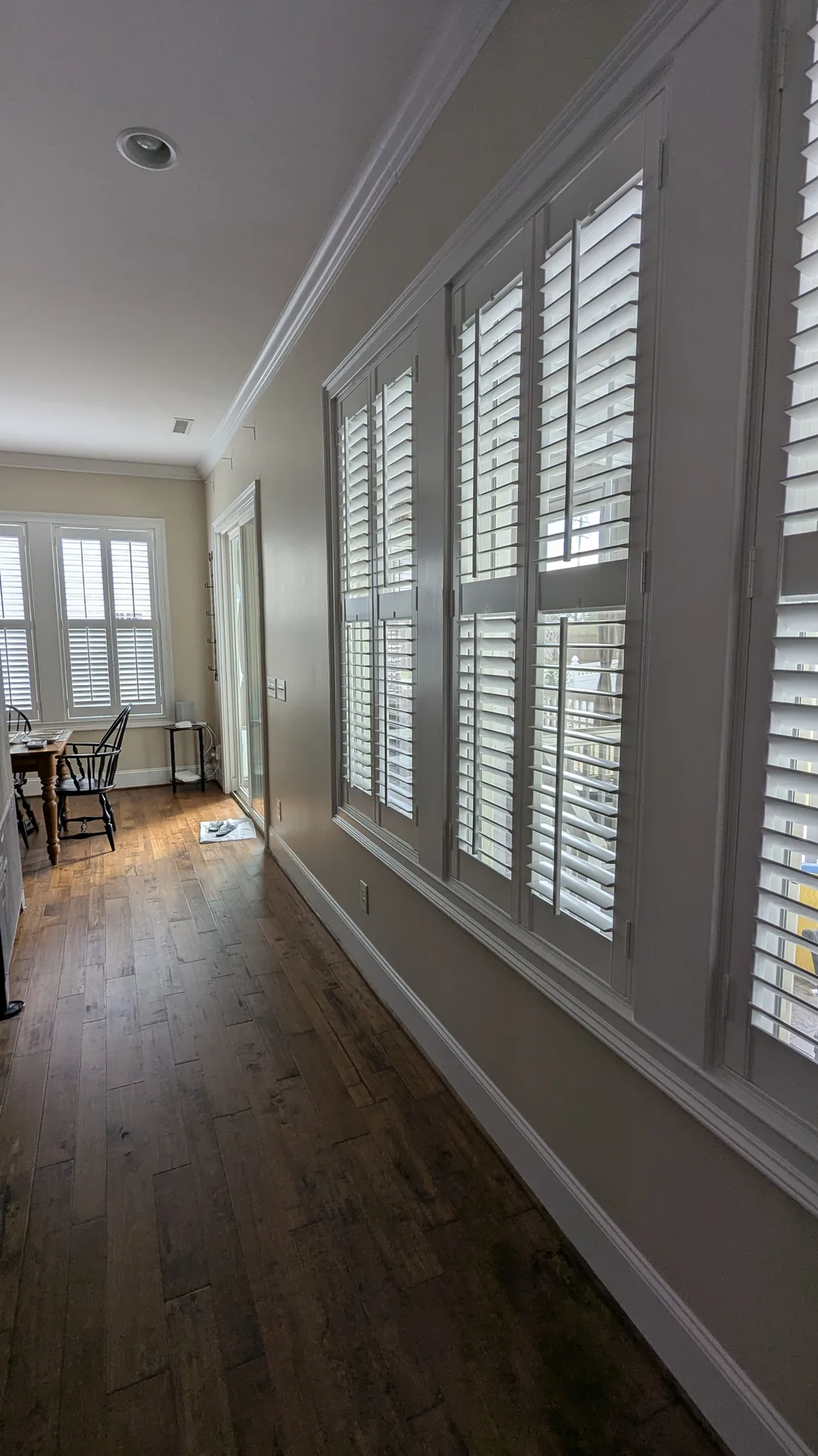 White window trim and plantation shutters along a painted interior wall